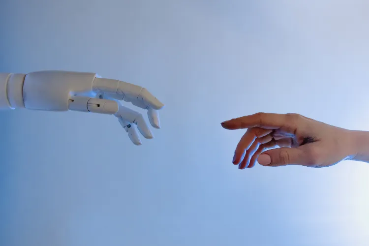 Robothand och hand som räcker efter varandra